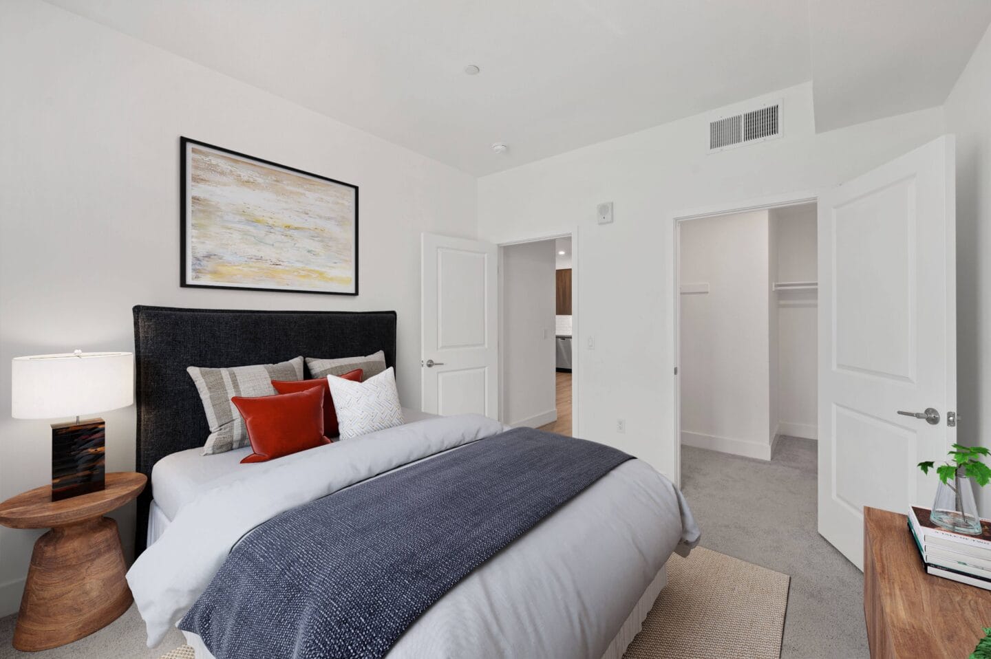 a bedroom with a large bed and a painting on the wall