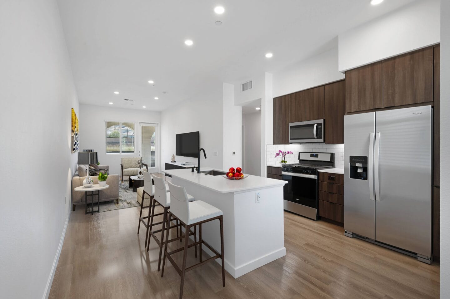 a kitchen with stainless steel appliances and a large island with chairs