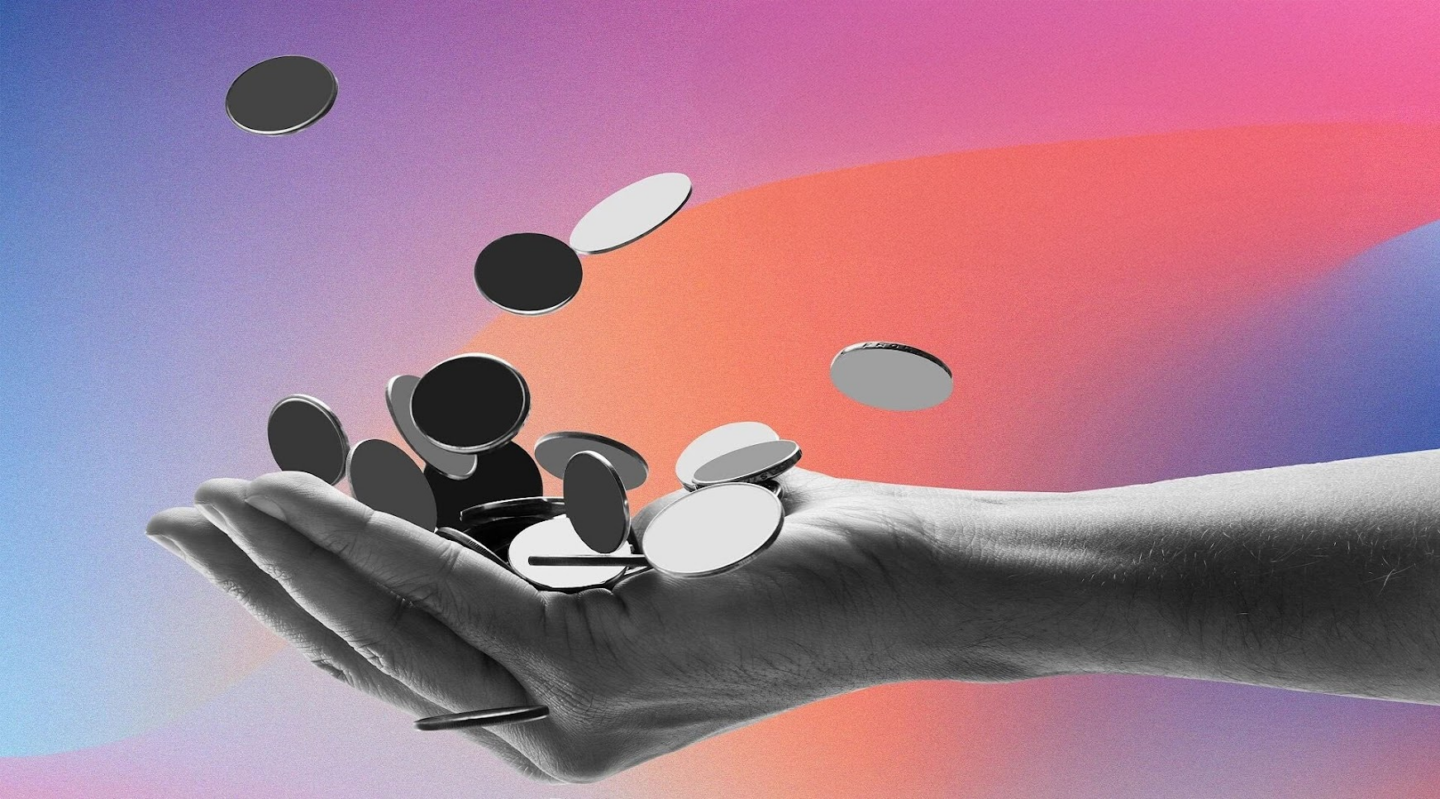 A hand grasping coins in front of a colorful backdrop, representing the opportunity to earn rewards through timely rent payments.