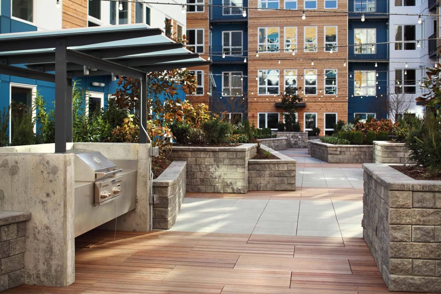 A patio with a grill and a building in the background at Windsor Ballard, 5555 14th Ave NW, Seattle, WA