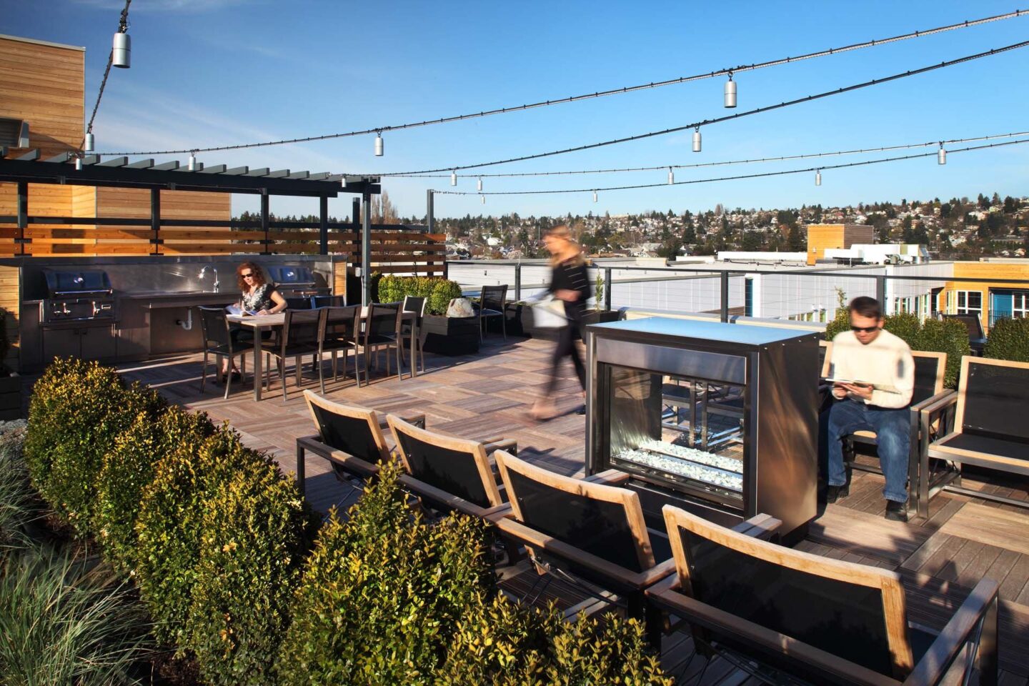 A man is sitting on a chair in front of a fireplace on a patio at Windsor Ballard, 5555 14th Ave NW, Seattle, WA