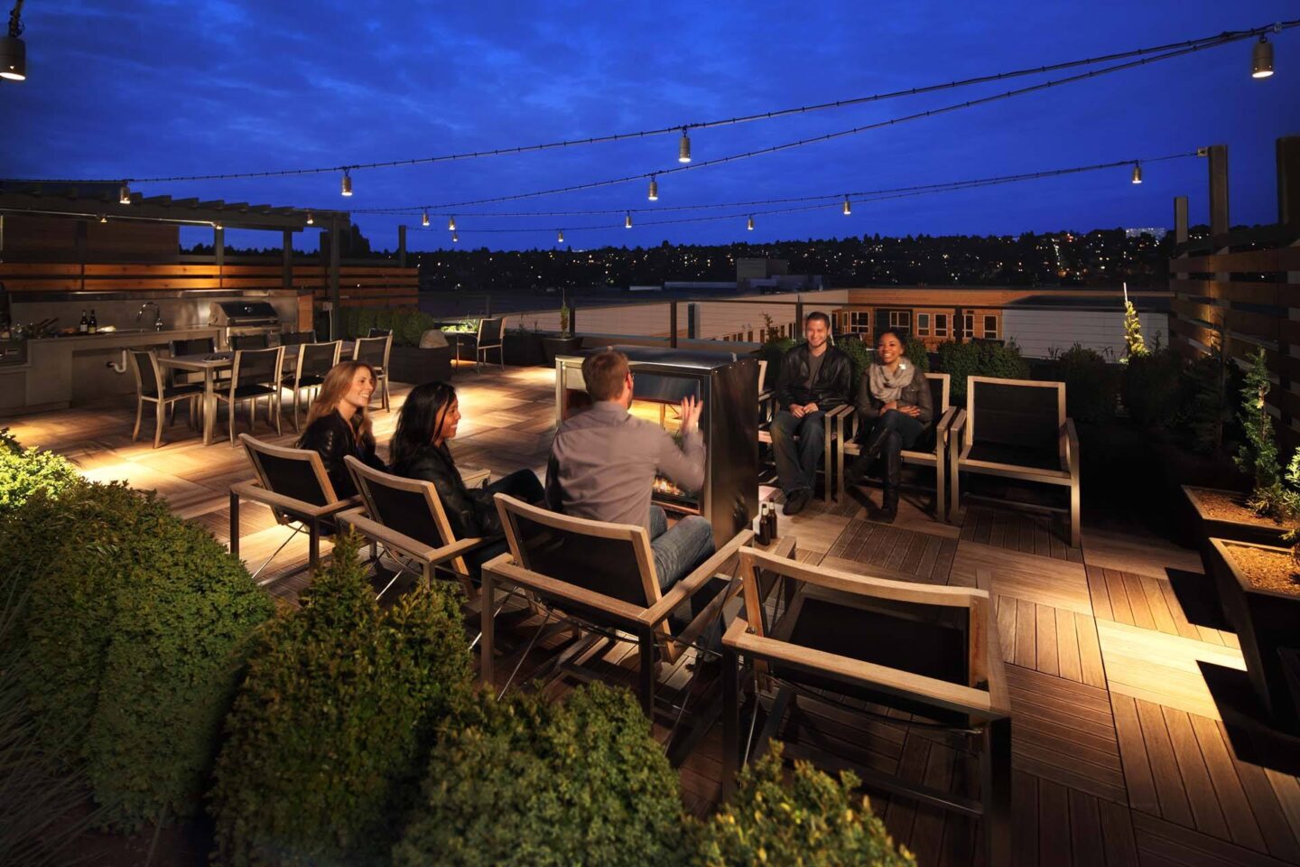 A group of people are sitting around a table on a rooftop patio at Windsor Ballard, 5555 14th Ave NW, Seattle, WA