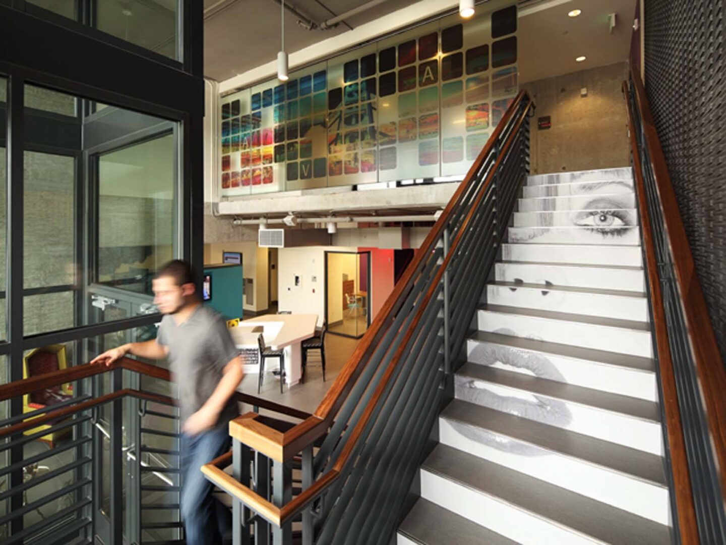 A man is walking up a staircase in a modern building at Windsor Ballard, 5555 14th Ave NW, Seattle, WA