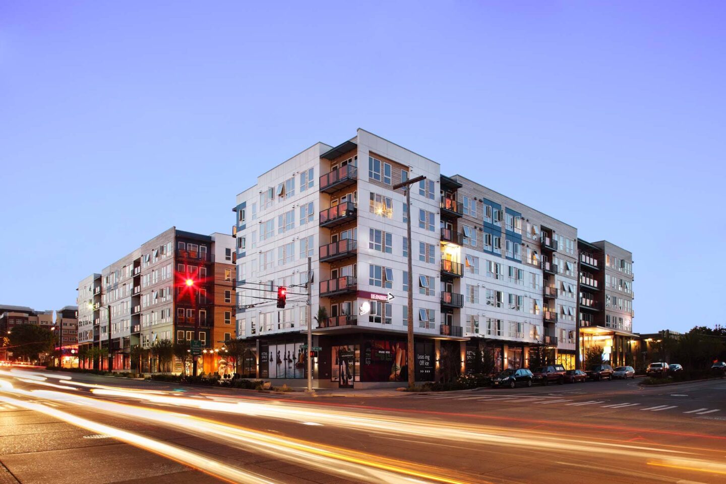 A long exposure shot of a street with a multi-story building in the background.