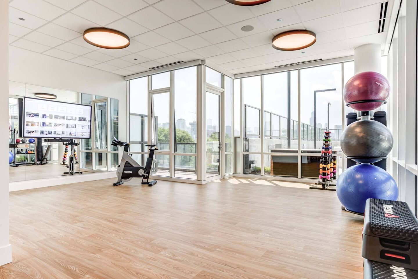 A gym with a variety of equipment including a treadmill, a stationary bike, and a rowing machine at Windsor North + Vine 633 W North Ave, Chicago, IL 60610.