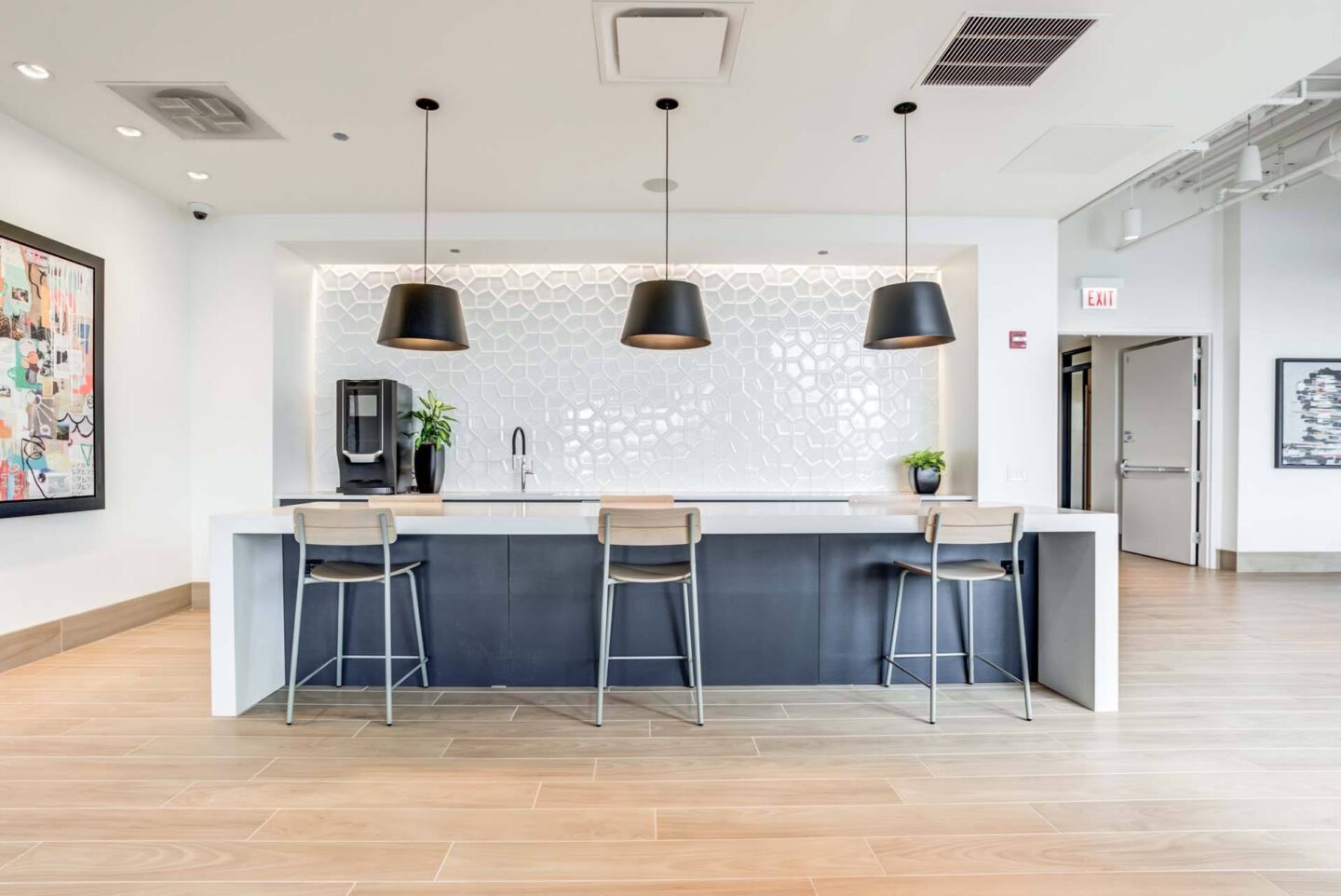 A modern kitchen with a bar area and pendant lights.