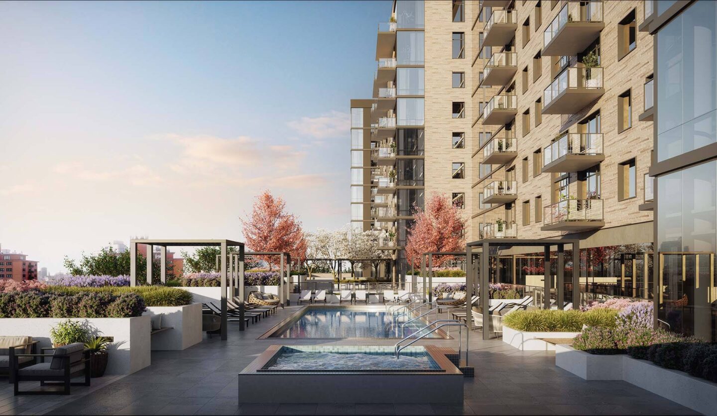 A modern outdoor pool area with a water feature in the center, surrounded by seating and greenery, with apartment buildings in the background at Windsor North + Vine 633 W North Ave, Chicago, IL 60610.