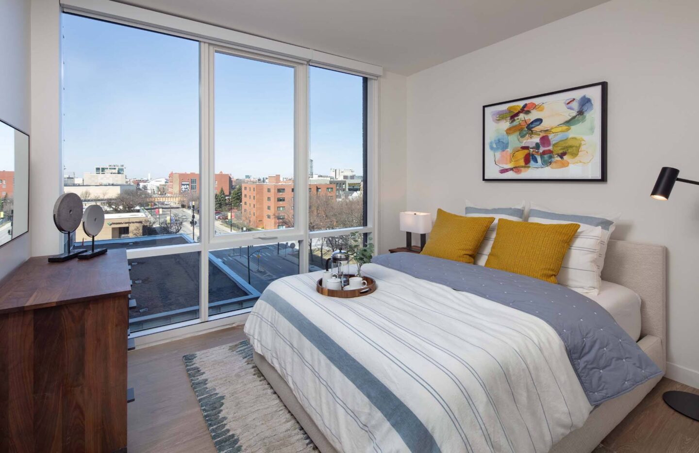 A bedroom with a large bed and a view of the city at Windsor North + Vine 633 W North Ave, Chicago, IL 60610.