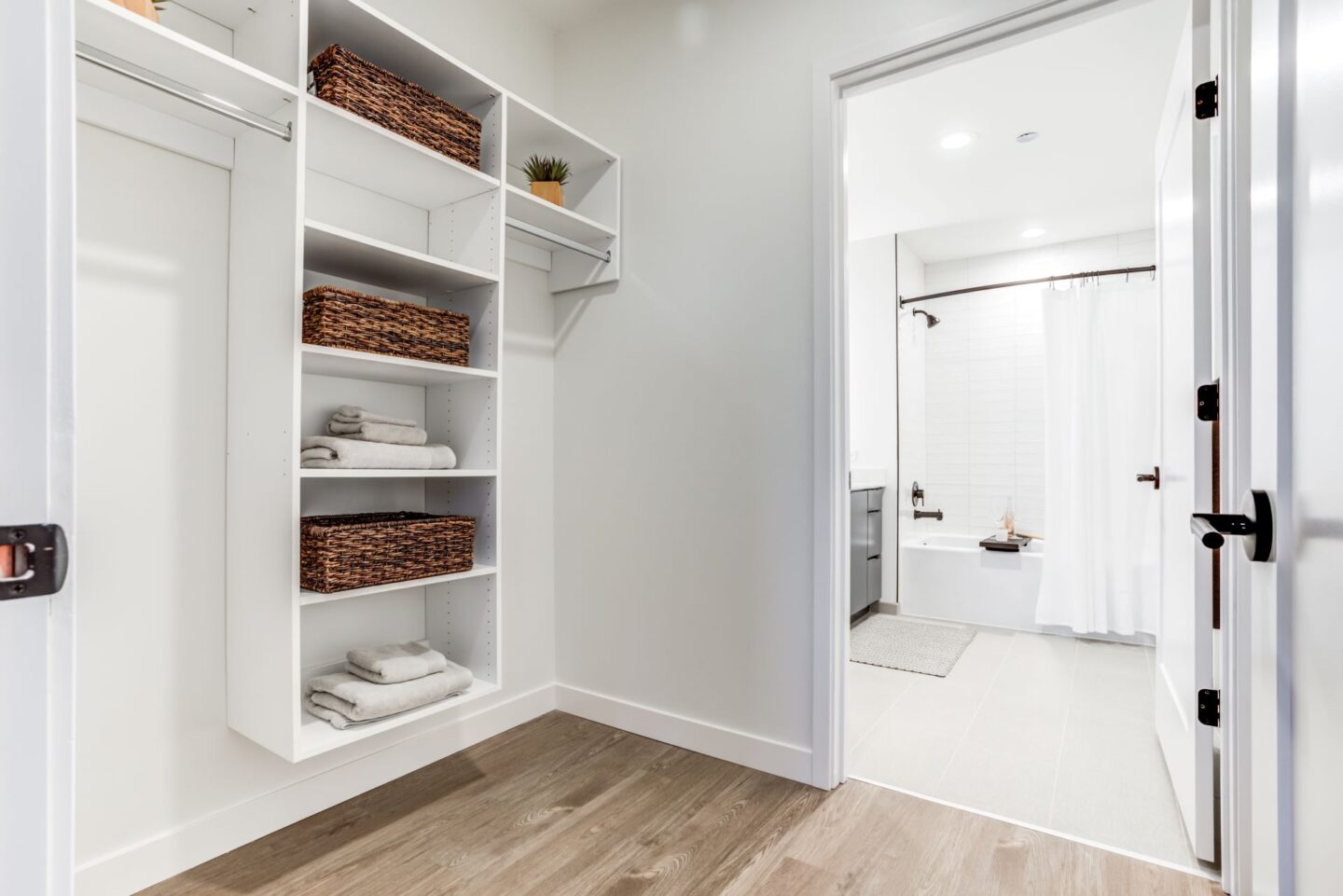 A white bathroom with a white cabinet and a white door.