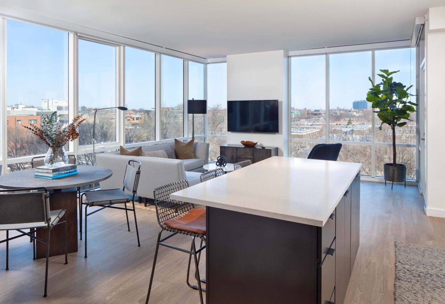 A modern living room with a large window overlooking the city at Windsor North + Vine 633 W North Ave, Chicago, IL 60610..