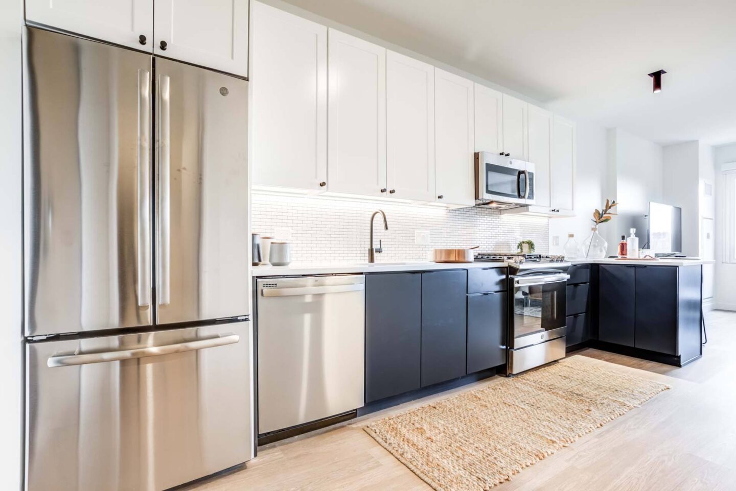 A modern kitchen with stainless steel appliances and white cabinets at Windsor North + Vine 633 W North Ave, Chicago, IL 60610.