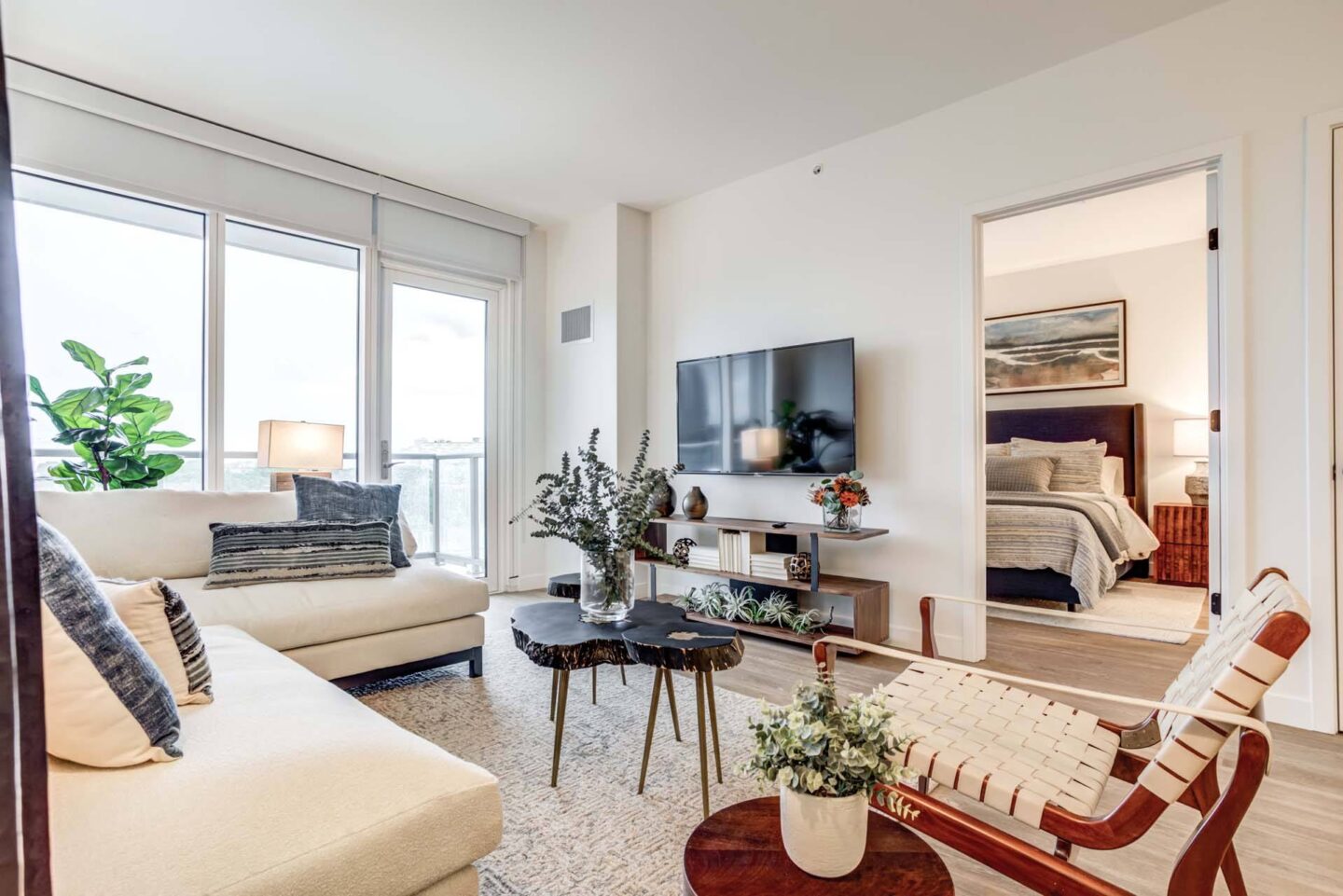 A living room with a white couch, a coffee table, and a television.