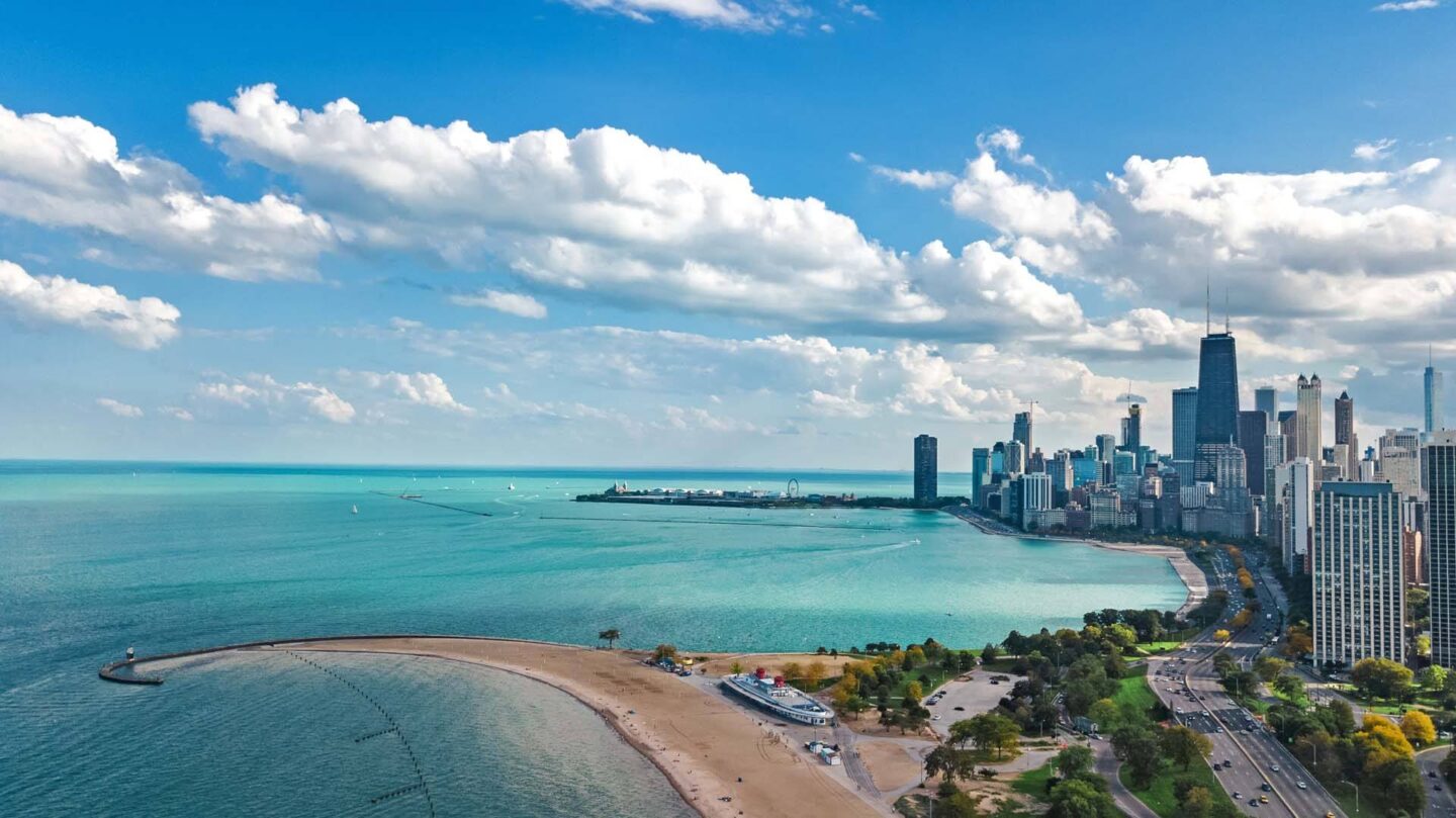 A city skyline is seen from a beach at Windsor North + Vine 633 W North Ave, Chicago, IL 60610.