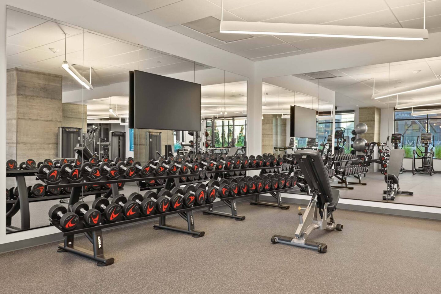 A fitness center with a row of stationary bikes and a television mounted on the wall at Windsor 3000 Huron, 3000. N. Huron Street, Denver, CO 80202.