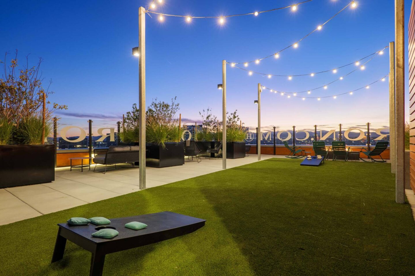 A rooftop lounge with cornhole and lights at Windsor 3000 Huron, 3000. N. Huron Street, Denver, CO 80202.