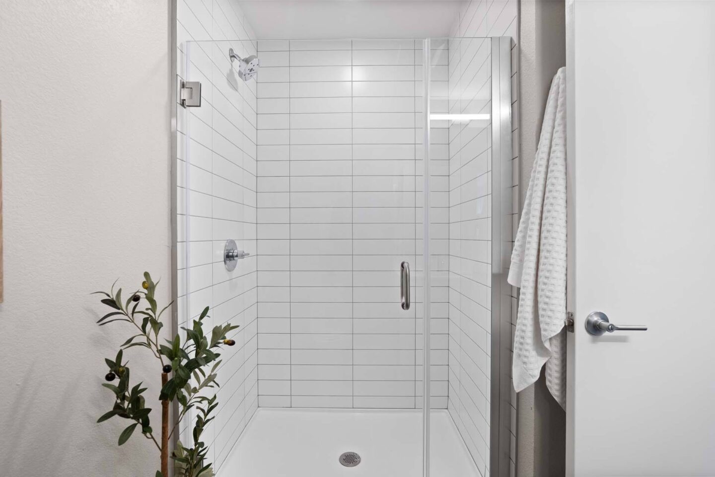 A white tiled shower at Windsor 3000 Huron, 3000. N. Huron Street, Denver, CO 80202.