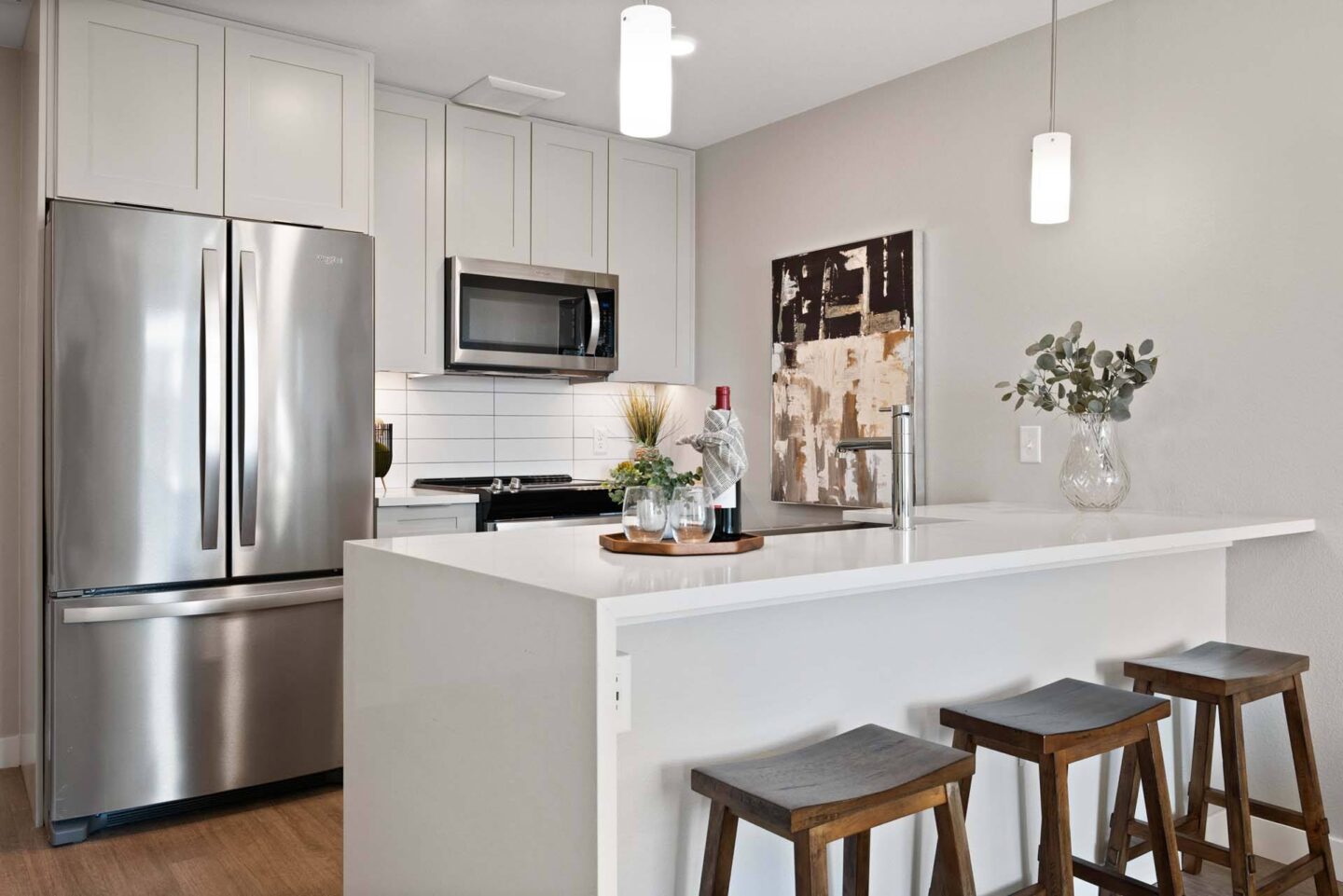 A modern kitchen with stainless steel appliances and white cabinets at Windsor 3000 Huron, 3000. N. Huron Street, Denver, CO 80202.