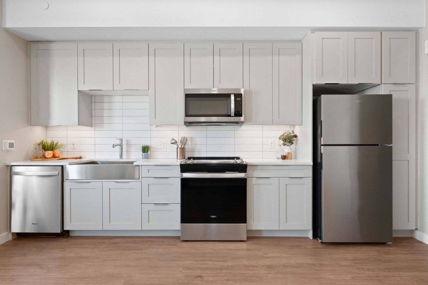 A modern kitchen with stainless steel appliances and white cabinets at Windsor 3000 Huron, 3000. N. Huron Street, Denver, CO 80202.