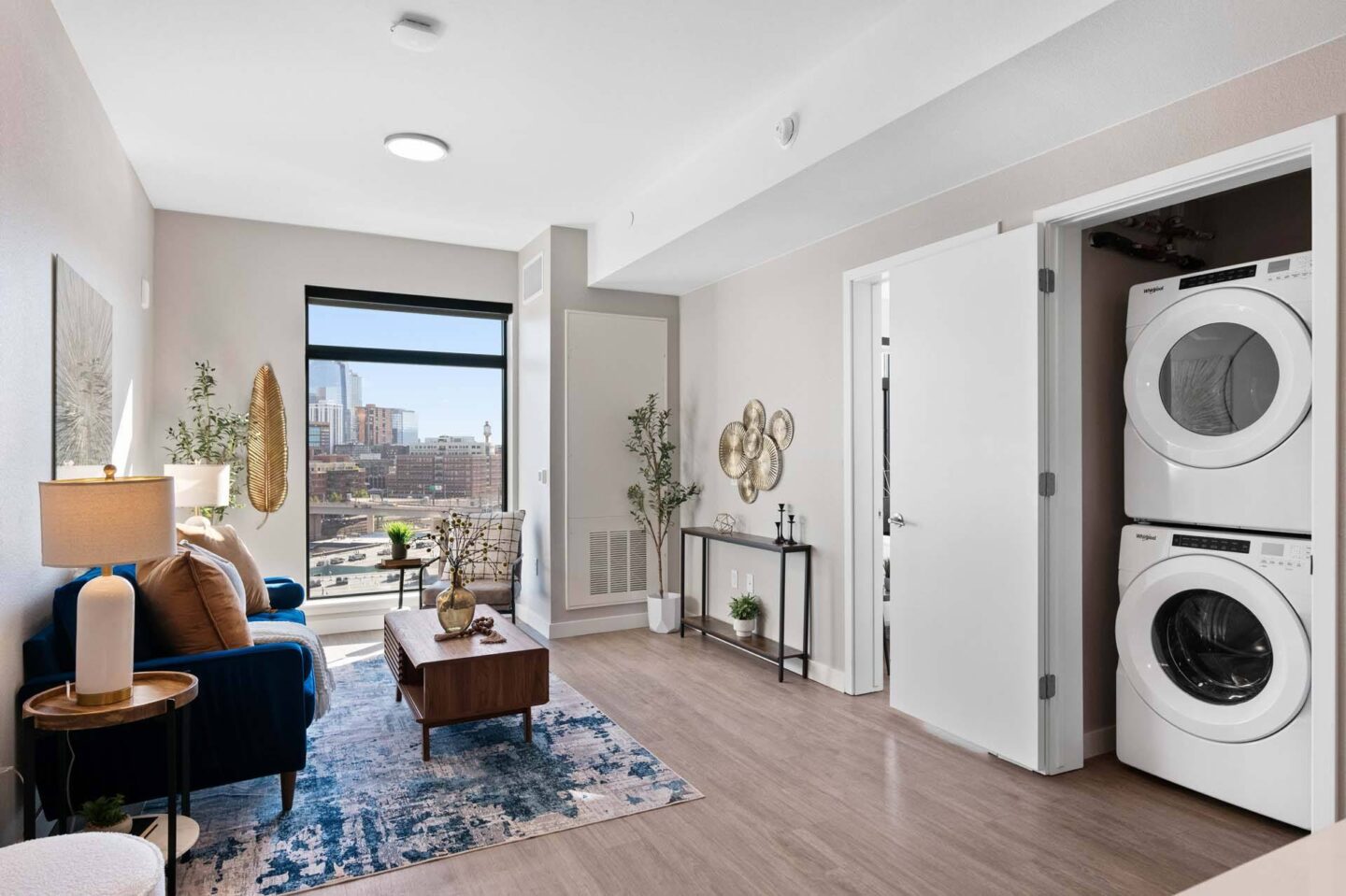 A modern living room with a washing machine and a view of the city at Windsor 3000 Huron, 3000. N. Huron Street, Denver, CO 80202.