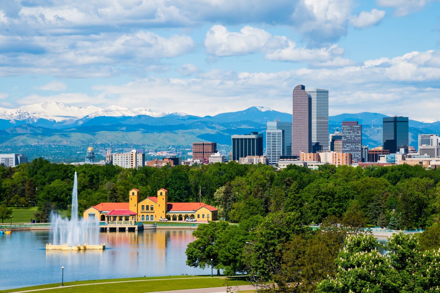 A cityscape with a fountain in the foreground and mountains in the background at Windsor 3000 Huron, 3000. N. Huron Street, Denver, CO 80202.